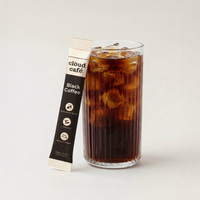 Glass of iced coffee with a 'cloud café' black coffee packet on a light gray background