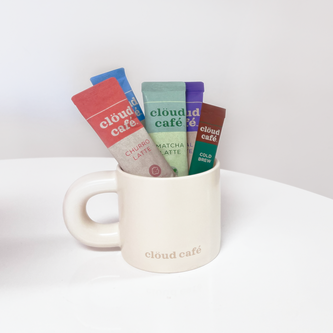 Cream colored mug with thick, chunky, rounded handle. Light tan "clöud café" logo on the bottom.