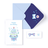 Cat peeking out of 2-tiered birthday cake with 1 candle. Greeting Card front message reads "happy birthday".