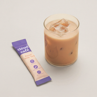 Cloud Café Royal Milk Tea package next to a glass of iced milk tea on a light background