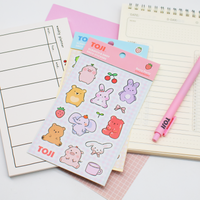 Sheet of cute animal stickers with a pink pen on a notebook