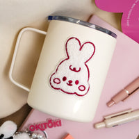 Furry plush bunny sticker on a white tumbler.