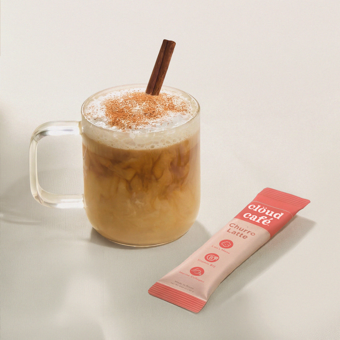 Clear mug of iced coffee with churro latte and a &