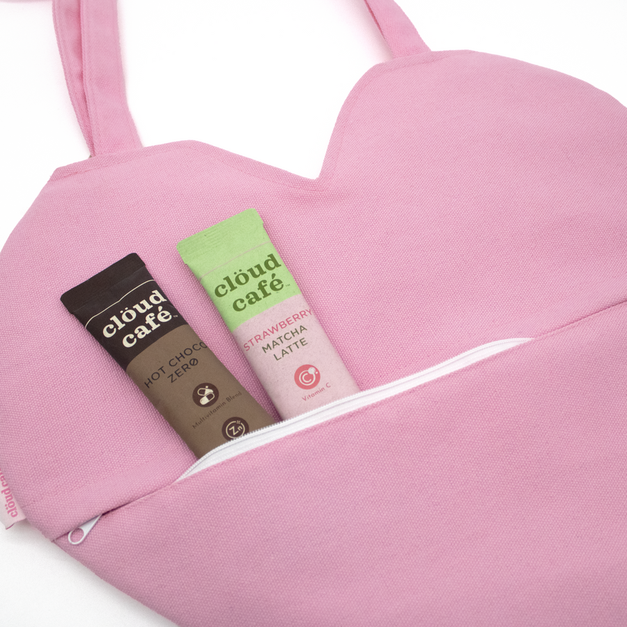 Heart-shaped pink tote bag with 'cloud cafe' text on a white background.  Zipper pocket on back of heart tote.