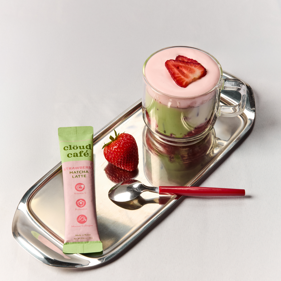 Strawberry Matcha Latte on silver tray with strawberry and spoon.