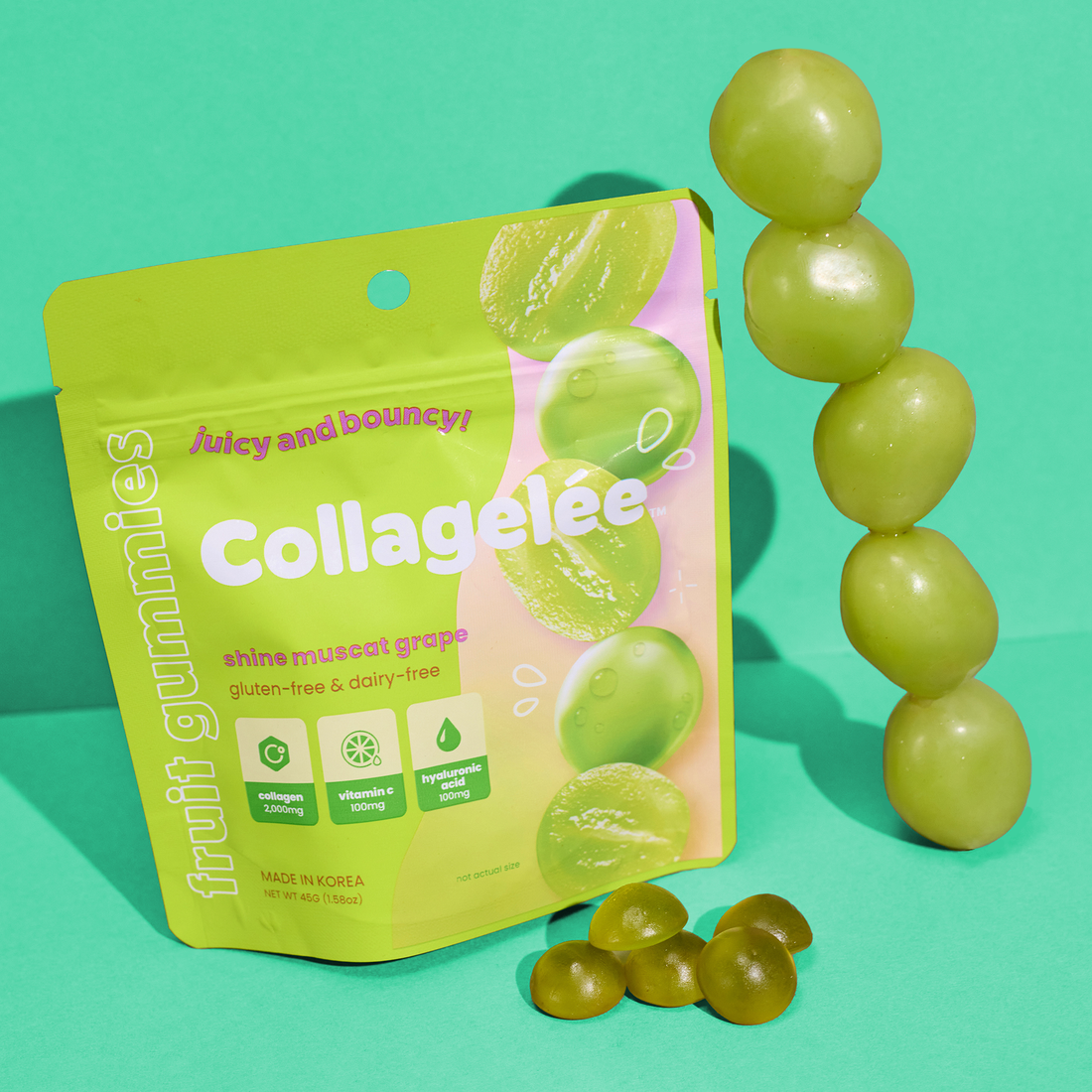 A package of shine muscat grape Collagen-Infused gummies on a teal green background next to grapes and gummies.