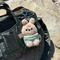 Otto keychain plush attached to black purse in lifestyle setting