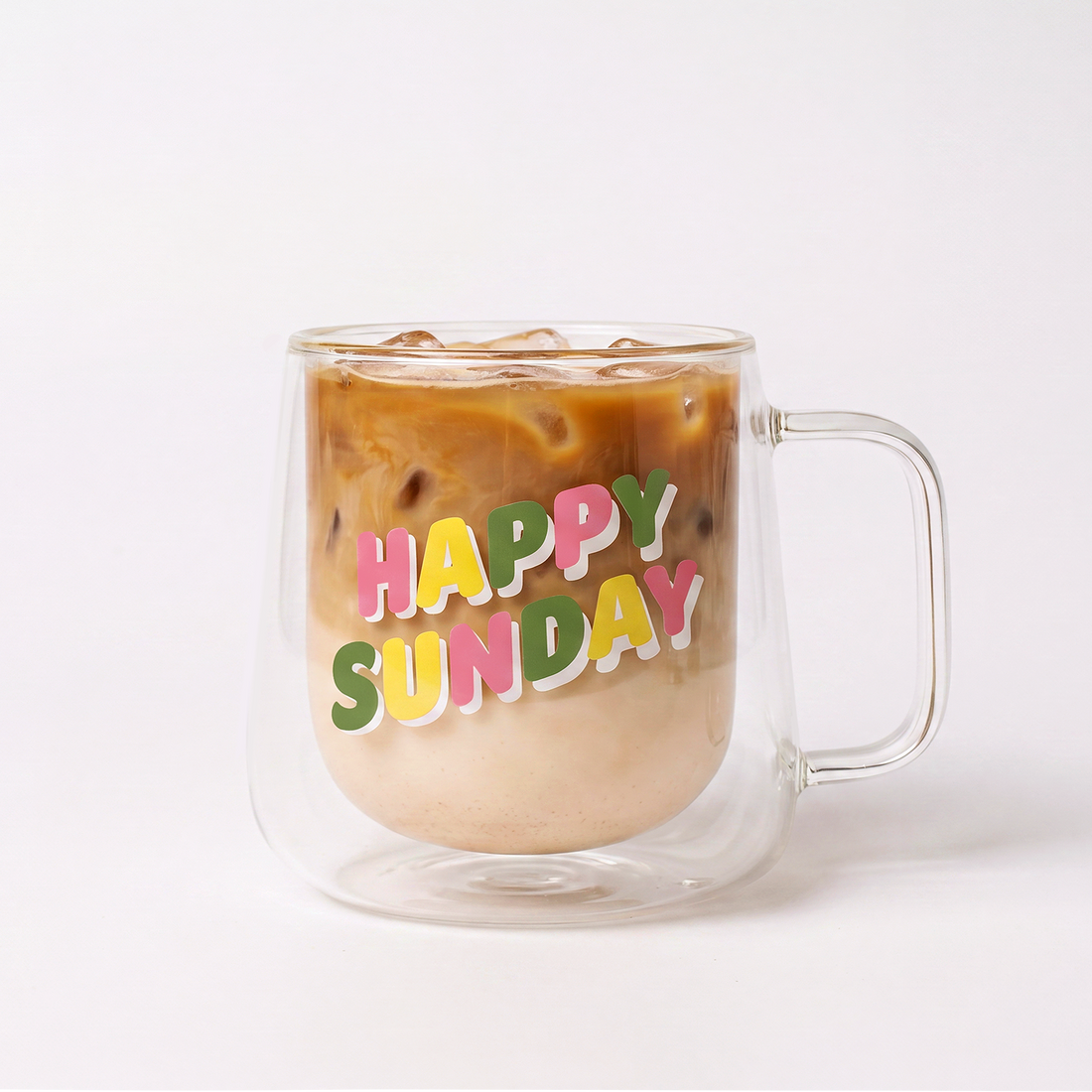 Clear "Happy Sunday" mug filled with Clöud Café collagen iced coffee behind a white background