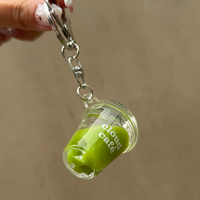 Mini iced matcha latte keychain with silver lobster clasp, clear acrylic cup charm, and “clöud café” logo – realistic shaker drink accessory with floating ice cubes for keys, purses, and bags.