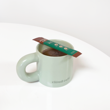 Pastel Green Chunk Mug. Thick rounded handle. Subtle dark green "Clöud Café" logo on bottom front of cup. 