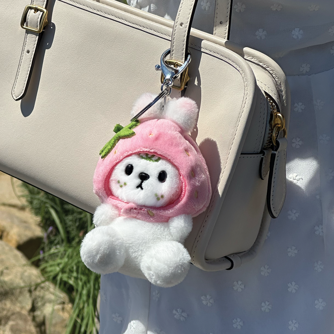 Otto plush keychain attached to bag in lifestyle setting