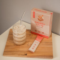 Churro Latte in a cute glass cup and glass straw. 