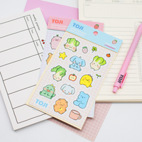 Sticker sheets with cute illustrations on a planner with a pink pen