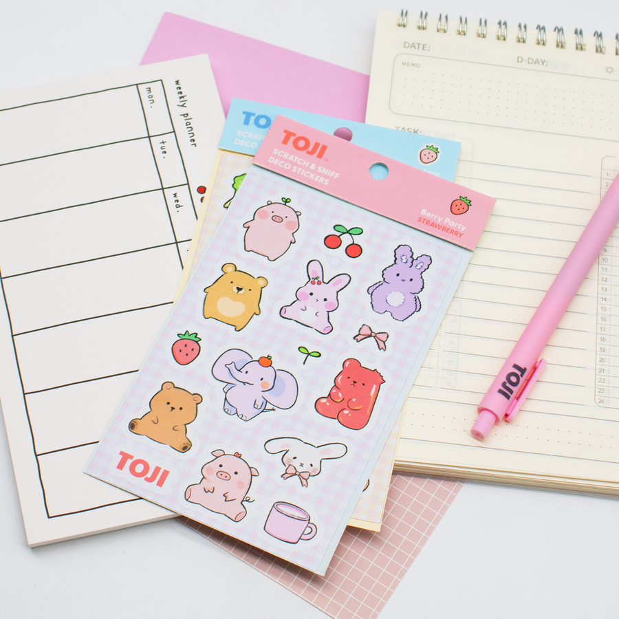 Sheet of cute animal stickers with a pink pen on a notebook