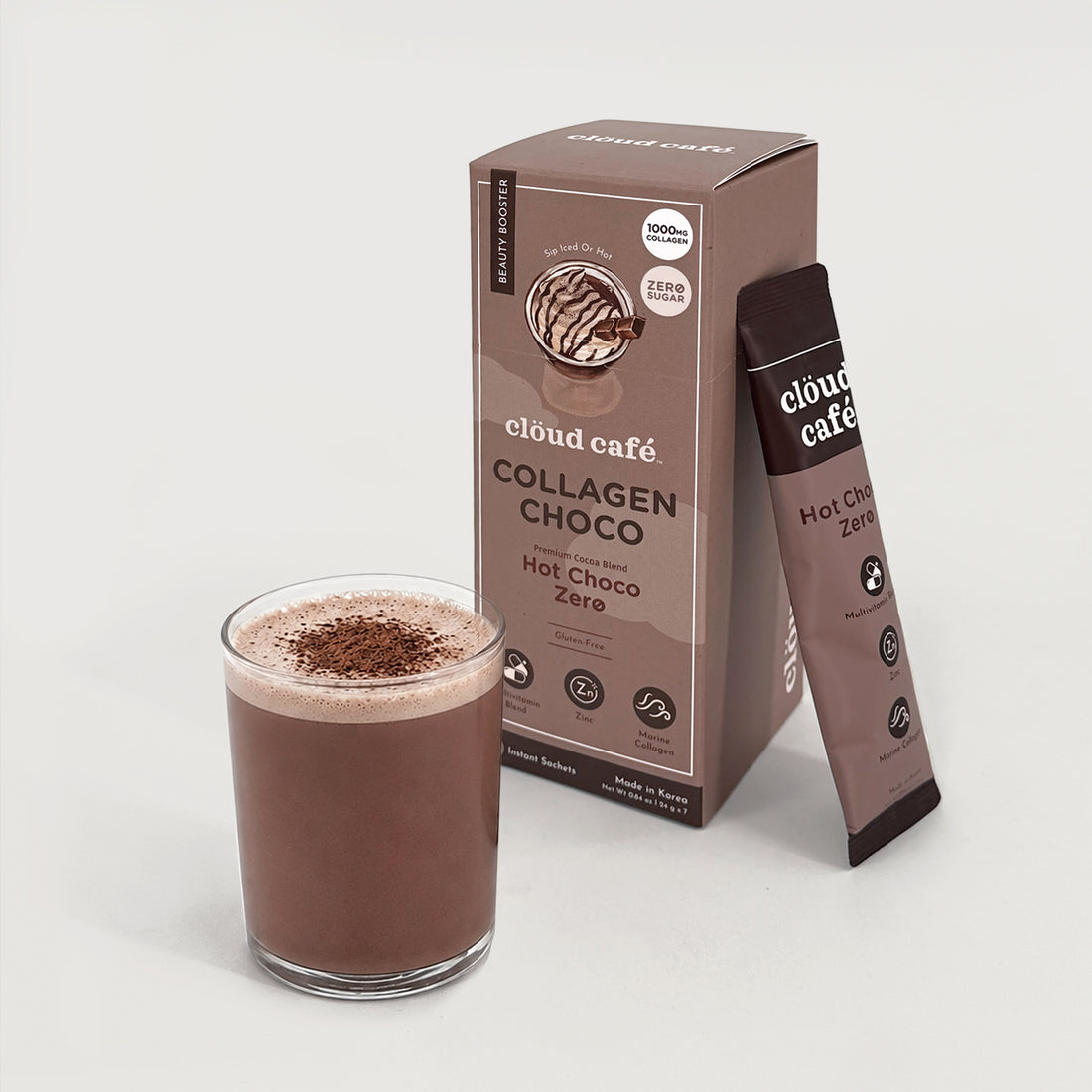Clöud Café Collagen Hot Choco Zero instant sachet box with frothy hot chocolate drink dusted with cocoa powder in clear glass, featuring 1000mg marine collagen, zinc, and multivitamin blend, zero sugar gluten-free Korean instant premium cocoa blend, 7 count.
