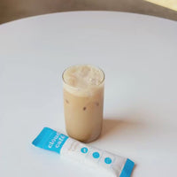 A step-by-step preparation of an iced latte. Add Clöud Café powder, a little bit of hot water, stir until smooth and frothy. Top with more water or milk to your desired taste. Drink iced or hot. 
