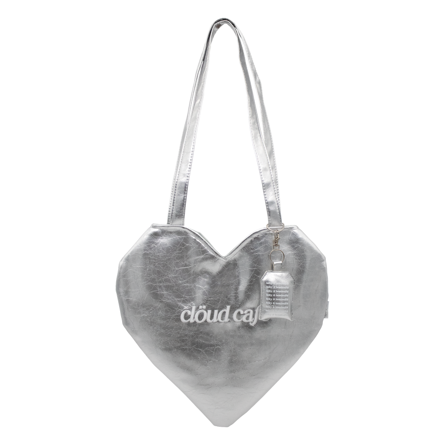 Silver heart-shaped tote bag with long over-the-shoulder strap. White Cloud Cafe embroidered logo. 